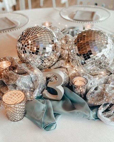 a-bright-and-shiny-wedding-centerpiece-of-blue-fabric-disco-balls-candles-and-a-table-number-is-a-cool-idea-for-a-glam-wedding.jpg